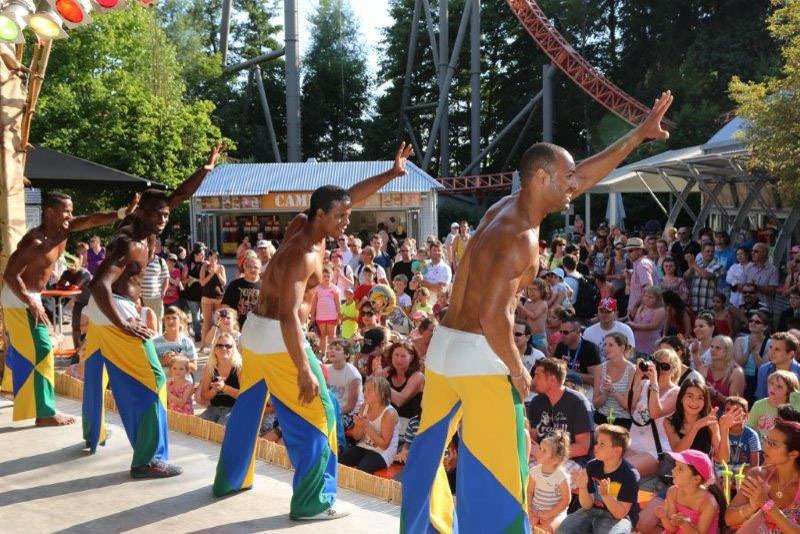Capoeira-Künstler auf einer Freizeitpark-Bühne vor Familienpublikum